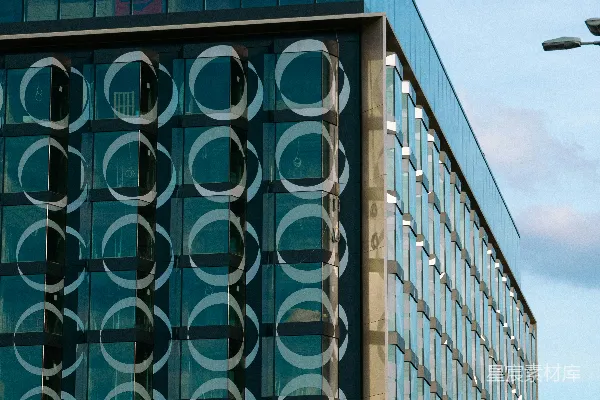 一座现代化建筑，带有玻璃外墙和圆形图案。