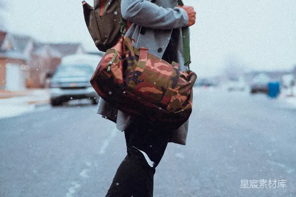 一个男人走在街上，手里拿着一个袋子