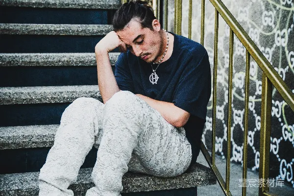 黑色上衣和灰色长裤的女人坐在台阶上