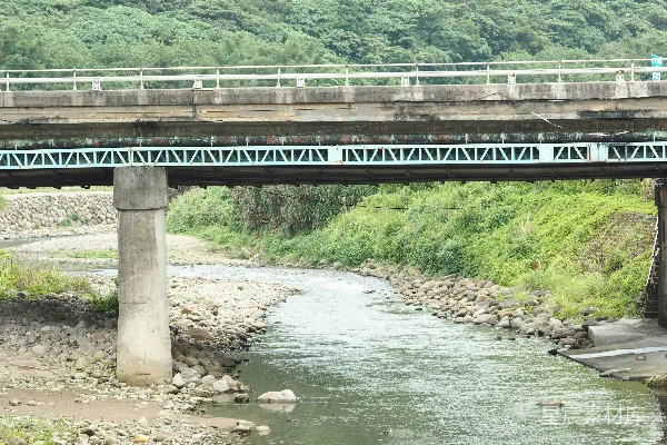 高清摄影 混凝土桥横跨在岩石河床上，周围是青翠的山丘。