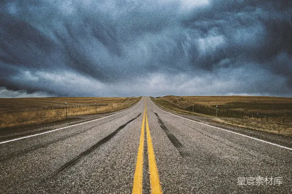 远处一片长直的公路在阴云密布的天空下延伸。
