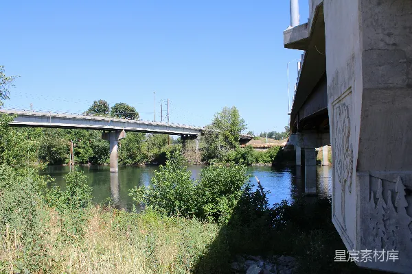 高清摄影 两座桥横跨一条河流，两岸环绕着绿树。