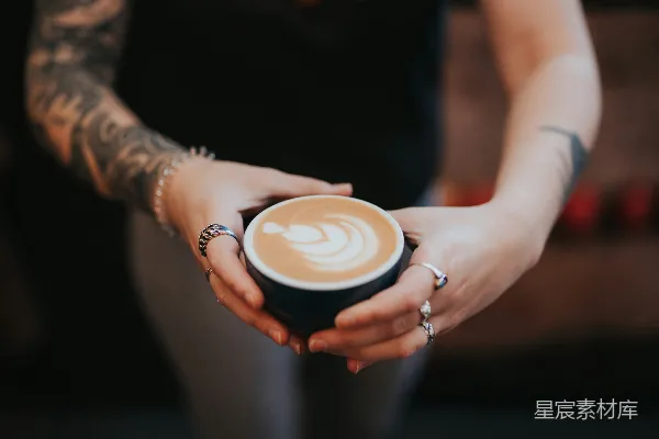手持白色陶瓷杯的人拿了一杯卡布奇诺