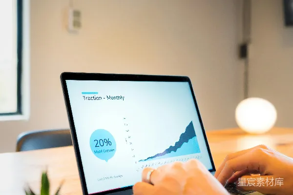 使用MacBook Pro的一个人坐在棕色木桌前。