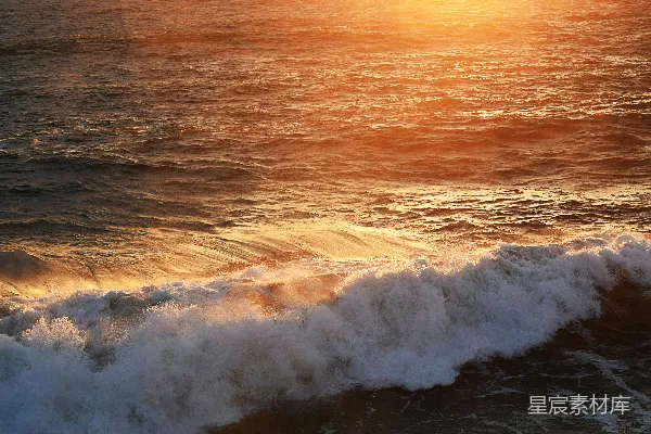 夕阳下海浪拍打海岸的景象