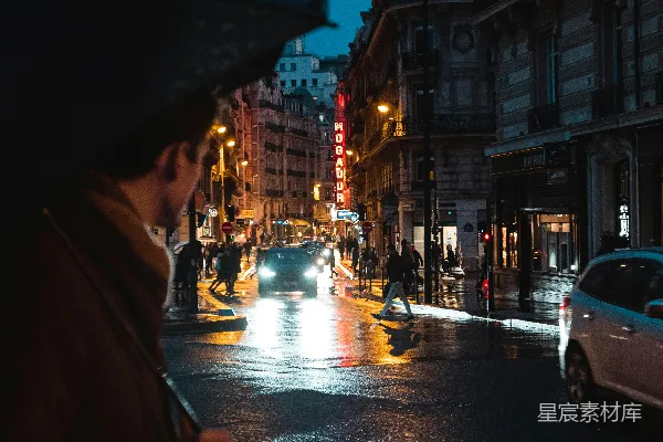高清摄影 穿着棕色外套的人撑着伞，晚上走在人行道上。