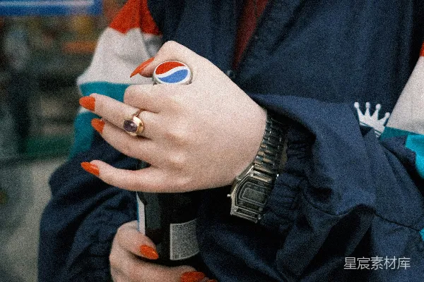 黑色夹克的人手持白色和蓝色的陶瓷杯