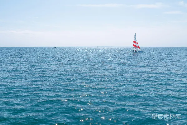 一艘孤舟在广阔的蓝色海洋中滑行。