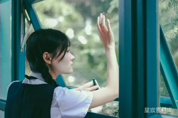 穿着学校制服的女士正向外看窗外。