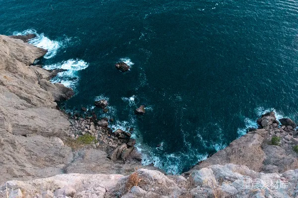 白天的棕色岩石海岸，蓝色海水