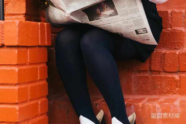 高清摄影 坐在混凝土台阶上读报纸的女人