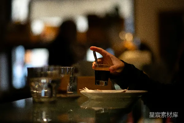 一个坐在桌子旁的人手中拿着一盘食物。
