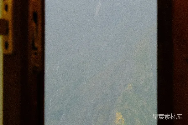 透过窗户看到的云雾缭绕的山脉景色。
