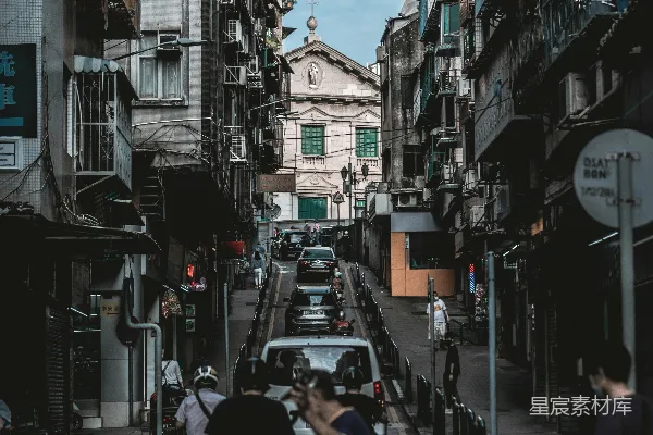 一个男人走在一旁有高大建筑物的街道上
