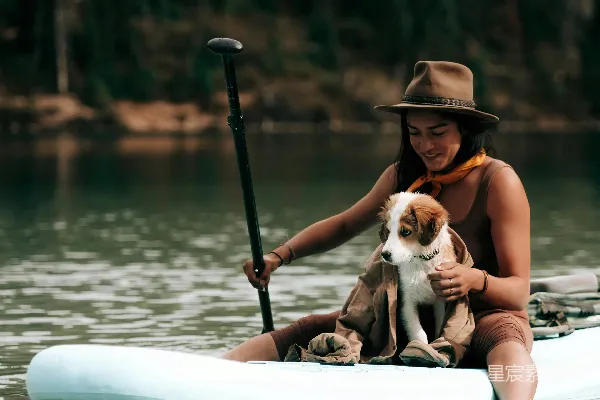 一个女人和她的狗在 kayak 中。