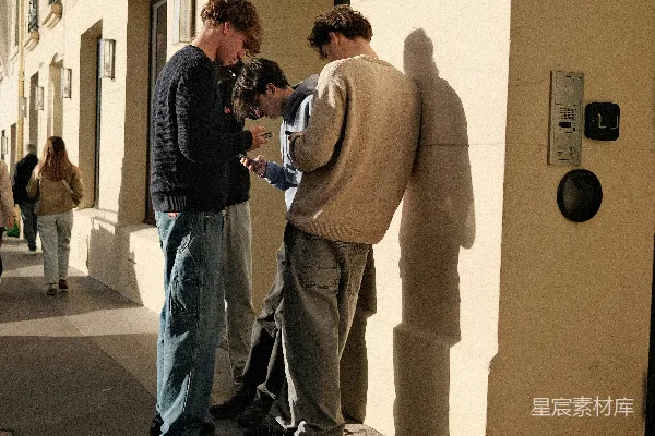 三名年轻人在户外看手机