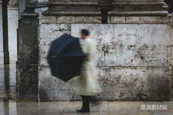 手持黑色雨伞的男人