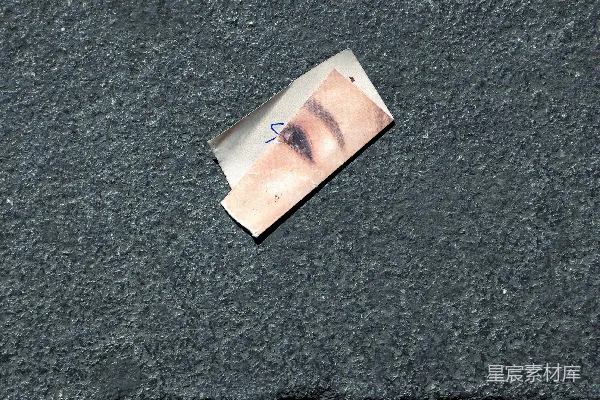 高清摄影 一张撕破的纸，上面有一只女人的眼睛。