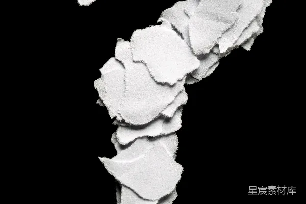 高清摄影 撕裂的纸片在黑色背景上形成了一个问号。