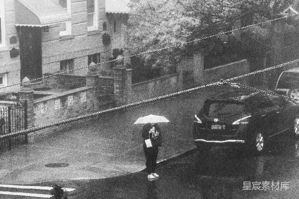 一张黑白照片中的人拿着雨伞