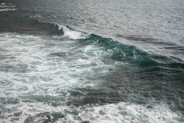 海边白天波浪拍击海岸的景象
