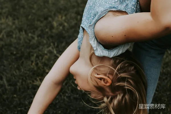 一个女子正在草地上做俯手倒立。