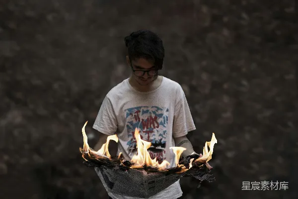 一个男子手握着一托火焰