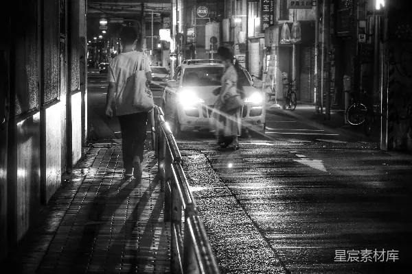 一个男人和一个女人在夜晚走在人行道上
