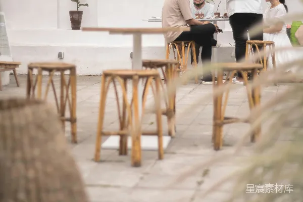 白色衬衣的男人坐在棕色木椅上。
