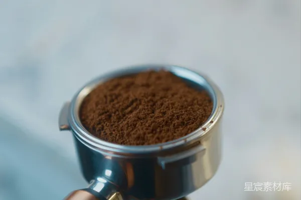 手里拿着一杯有勺子的咖啡的人