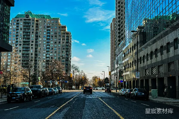 一条被高大建筑和停着的汽车环绕的城市街道