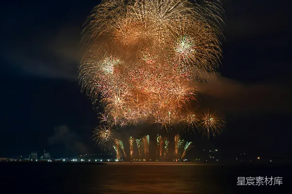 夜幕下烟花在水面上空绽放。