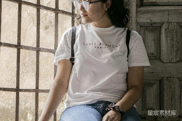 一个女人坐在窗台上向外看。