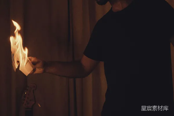 高清摄影 抱着燃烧物靠近吉他的人