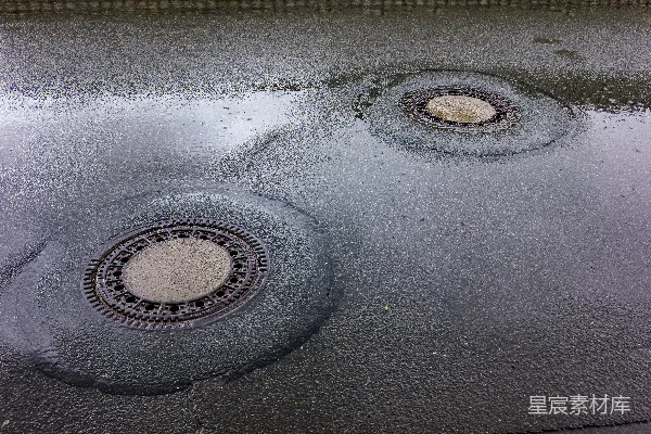 两个雨后反光街道上的井盖。