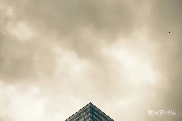 一座高楼矗立在阴云密布的天空下