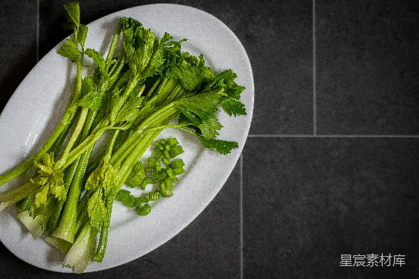一片白色的盘子上摆放着绿色的叶菜。