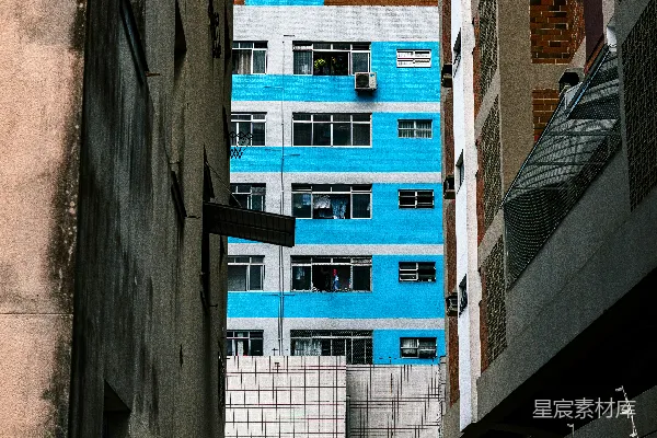 一座蓝白相间的建筑位于其他两座建筑之间。