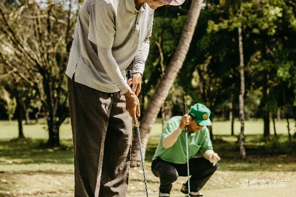戴帽子的男人正在打高尔夫球