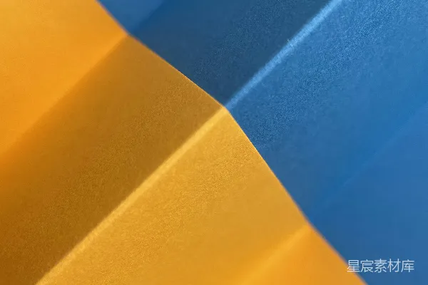 高清摄影 抽象的蓝黄几何褶皱形成了一个充满动感的图案。