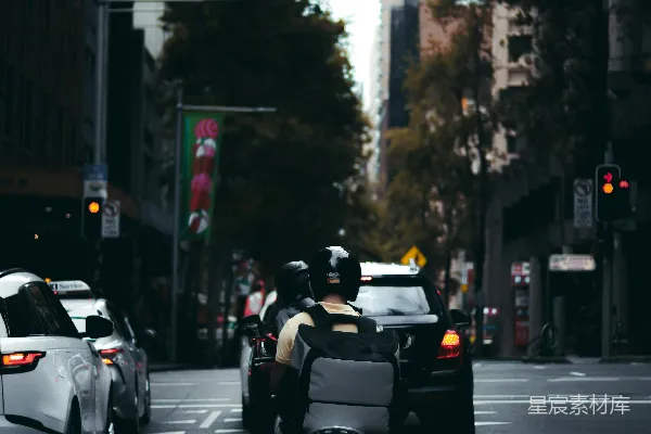 白天人们骑摩托车在路上行驶