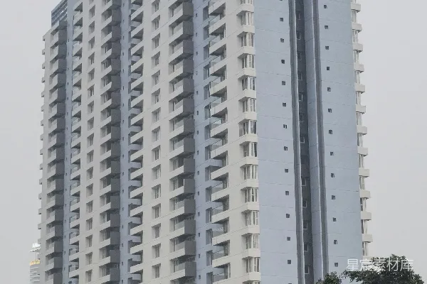 高公寓建筑上有许多阳台，背景是弥漫的天空。