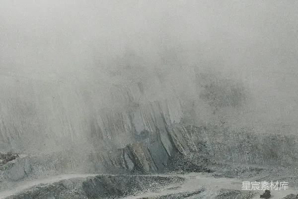 山顶上站着一个人，身后是覆盖着积雪的山峦。