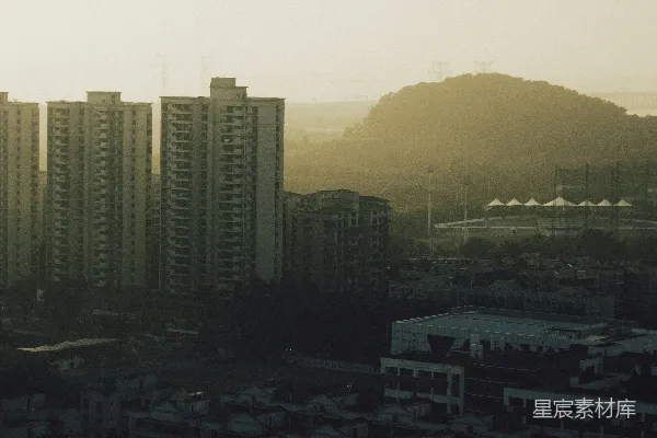 高耸的公寓建筑在日落远处的山丘上。
