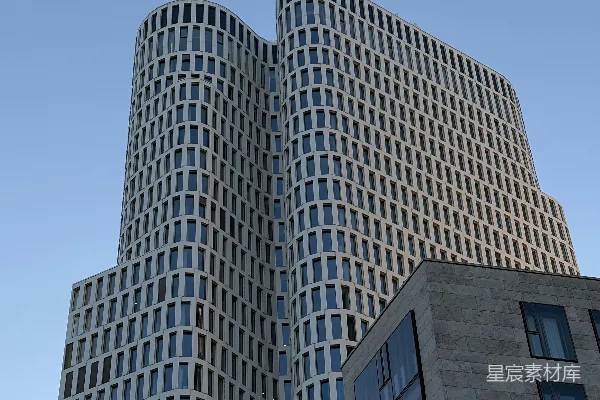 现代 skyscraper 有弯曲的立面，在蓝天背景下。