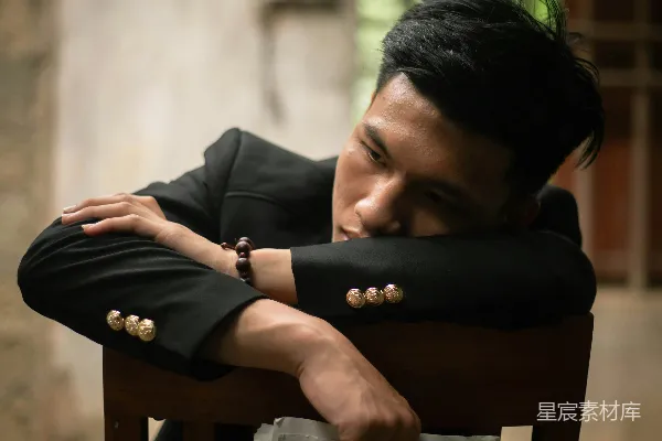 高清摄影 穿灰色衬衫的男人坐在棕色木椅上阅读书籍。