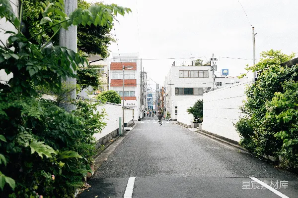 空旷的街道两侧有建筑和绿色植被