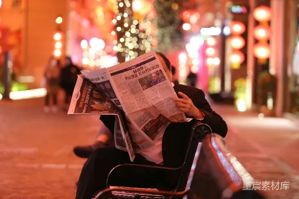 高清摄影 坐在椅子上看报纸的人