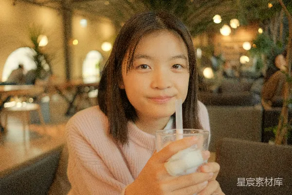 一个年轻女孩喝着一杯牛奶