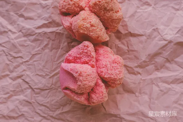 高清摄影 一堆粉色的甜甜圈放在一张纸上。